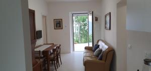 uma sala de estar com um sofá e uma mesa em casa nel verde della Val di Vara em Serò