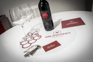 uma garrafa de vinho e duas taças sobre uma mesa em Wine Apartments Florence Masseto em Florença