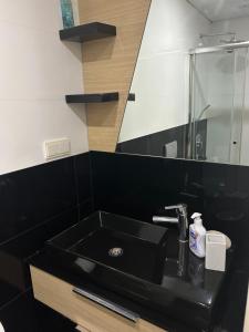 a bathroom with a black sink and a mirror at Platform merter apartment in Istanbul