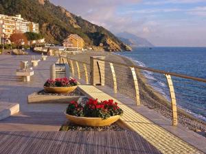 two baskets of flowers on a boardwalk next to the ocean at Eden Hotel in Deiva Marina