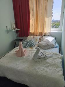 dos animales de peluche en una cama con ventana en - PANORAMA -, en Sopot