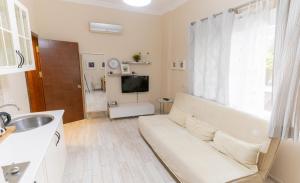 een badkamer met een bank en een televisie in een kamer bij LEVANT HOTEL&APARTS in Çeşme