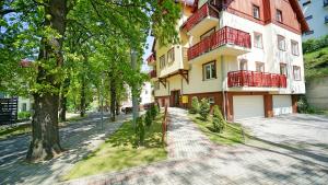 an apartment building with a balcony on a street at Apartamenty Every Sky Nad Łomnicą 1b-6b in Karpacz