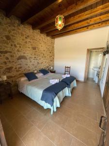 a bedroom with two beds and a stone wall at Habitacion rural en Alora Caminito del Rey in Málaga