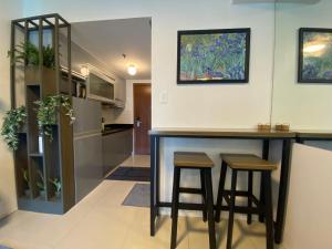 a kitchen with a bar and stools in a room at Luxury Condo with Pool View at Shell Residences in Manila