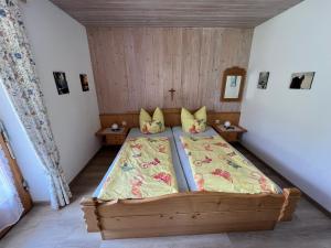 - une chambre avec un grand lit en bois dans l'établissement Haus Stiafei, à Schneizlreuth