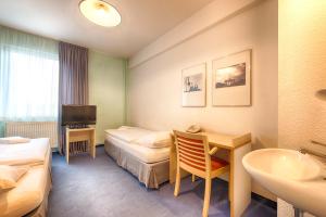 ein Hotelzimmer mit 2 Betten und einem Waschbecken in der Unterkunft enjoy hostel Berlin City West in Berlin