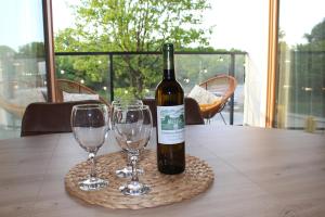 a bottle of wine sitting on a table with two wine glasses at Gdańsk Porto Apartments in Gdańsk