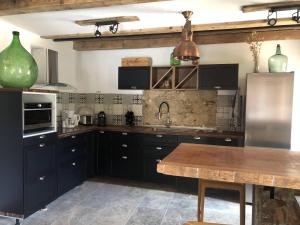 a kitchen with black cabinets and a wooden table at The Charming House by 1722 in Ville-di-Paraso