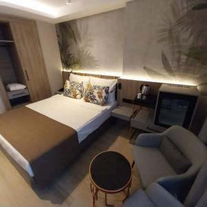 een slaapkamer met een bed, een bank en een tv bij ALESSIA HOTEL & SPA in Side