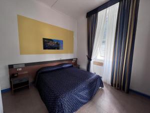 a bedroom with a bed and a large window at Eden Hotel in Deiva Marina
