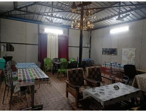 a room with tables and chairs in a room with a room at Sumeru Camp,Barkot in Barkot