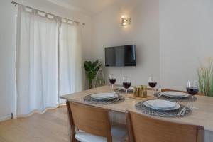 une salle à manger avec une table et deux verres de vin dans l'établissement Cozy Apartment - 100m from the beach Punta, à Pakoštane