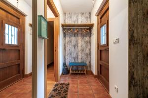 un pasillo con puertas de madera y un taburete azul en Ortzimuga, en Huarte