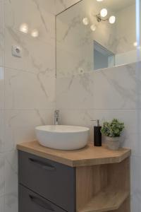 een badkamer met een wastafel en een spiegel bij Cozy Apartment - 100m from the beach Punta in Pakoštane