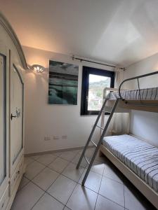 a bedroom with a bunk bed and a ladder at Appartamento 28 - Complesso Residenziale Terme di Casteldoria in Santa Maria Coghinas +11 photos