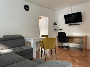 sala de estar con sofá, mesa y TV en Jura en Zagreb