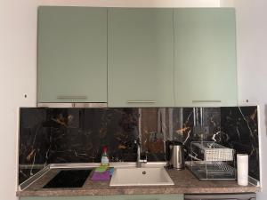 a kitchen with white cabinets and a sink at Ntina's Room in Nea Potidaea +16 photos
