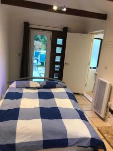 ein blau-weißes Bett in einem Zimmer mit Fenster in der Unterkunft Self contained annex in Bournemouth