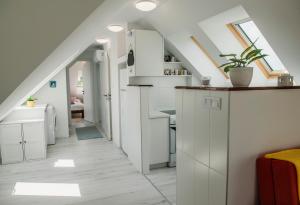 a kitchen with white cabinets and a staircase at Pécs City View- free parking in Pécs