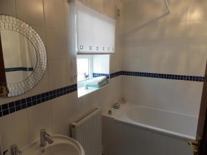 a bathroom with a tub and a sink and a mirror at Waterloo Cottage in Barnard Castle