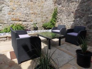 a patio with three chairs and a table at Waterloo Cottage in Barnard Castle +4 photos