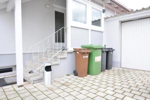 ein Haus mit zwei Mülltonnen und einer Treppe in der Unterkunft ROH01-RI Apartment in Rohr 