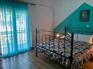 een slaapkamer met een bed in een kamer met ramen bij Litsa's House in Neos Marmaras