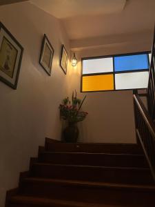 a staircase with a window and a vase of flowers at Pha Thai House in Chiang Mai