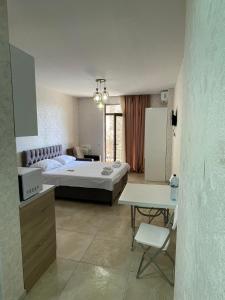 a bedroom with a bed and a table and a desk at Europalace Gonio in Gonio