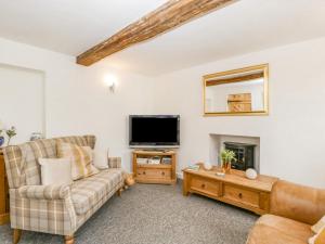 a living room with a couch and a tv at 4 Wallflower Row in Hereford