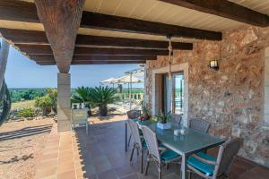 a patio with a table and chairs on a stone wall at Sa Marina des torrent - Grupo Berna in Ses Salines