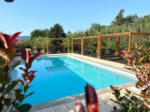 una piscina de agua azul en un patio en Le Village Sarzana, en Sarzana