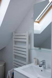 a white bathroom with a sink and a mirror at Pécs City View- free parking in Pécs