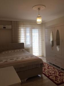 ein Schlafzimmer mit einem Bett und einem großen Fenster in der Unterkunft Rahat ve Konforlu in Araklı