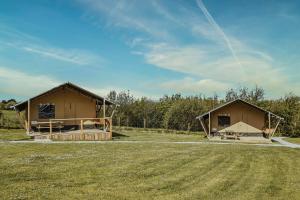 two huts in a field next to a field at Little Pig Glamping in Bude