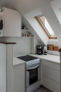 a kitchen with white cabinets and a stove at Pécs City View- free parking in Pécs