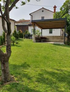 einen Hinterhof mit einem Picknicktisch und einem Haus in der Unterkunft APARTMA KMETIJA ROVAN in Vrhpolje