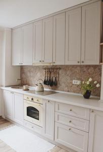 a white kitchen with white cabinets and a stove at Cetate boulevard Apartment in Alba Iulia