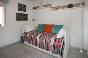 a white room with a bed with a colorful blanket at Ground Floor Bellaluz Apartment - La Manga Club in Atamaría