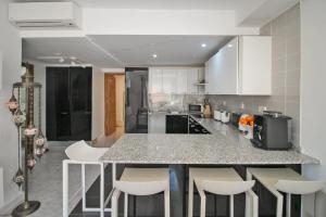 a kitchen with a counter and some white cabinets at Ground Floor Bellaluz Apartment - La Manga Club in Atamaría