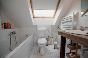 a bathroom with a toilet and a tub and a sink at Pécs City View- free parking in Pécs