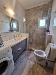 Un baño con inodoro, lavabo y ducha. en Luxury & Modern Apartment, en Paralia Katerinis