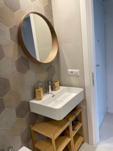 a bathroom with a white sink and a mirror at La Finestra sul Mare Modern Apartment in Giardini Naxos