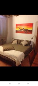 a bedroom with two beds and a painting of horses on the wall at Appartamento centro Lecco in Lecco
