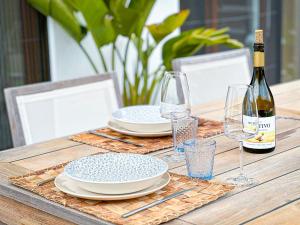 einen Tisch mit Tellern und Gläsern sowie eine Flasche Wein in der Unterkunft Salthouse Portugal - Exclusive East Apartment in Aljezur