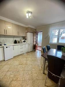 a kitchen with white cabinets and a table with chairs at Casa Teresa in Cluj-Napoca