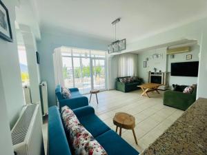 a living room with blue couches and a tv at Mountain Valley Oludeniz in Oludeniz