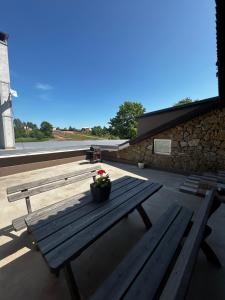 a wooden picnic table with a pot of flowers on it at Atpūtas komplekss ''Klintis'' in Bauska