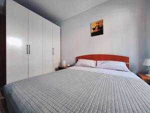 a bedroom with a large bed and white cabinets at Appartamento Casa Bruno in Porto SantʼElpidio